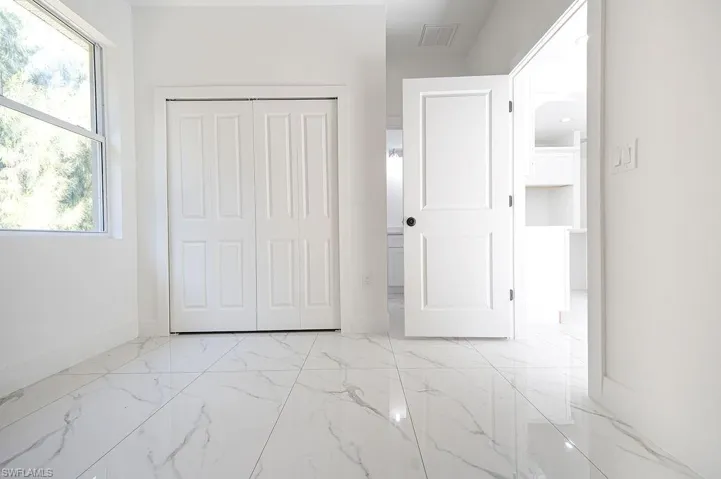 Unfurnished bedroom featuring a closet and light marble finish floors. Photos are of a staged model or similar plan. Features and finishes may vary.