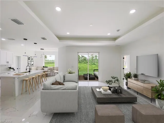 Living room with light marble finish floors, recessed lighting, and a raised ceiling. Photos are of a staged model or similar plan. Features and finishes may vary.