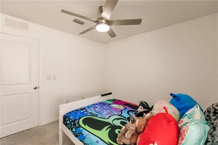 Carpeted bedroom with ceiling fan