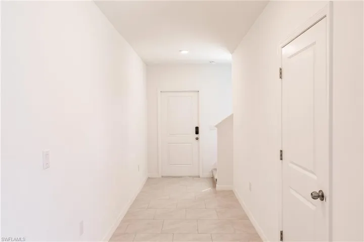 Hall featuring light tile patterned flooring