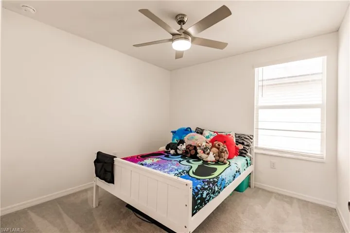 Carpeted bedroom featuring ceiling fan