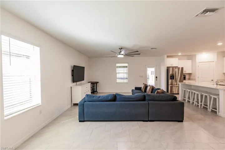 Tiled living room featuring ceiling fan
