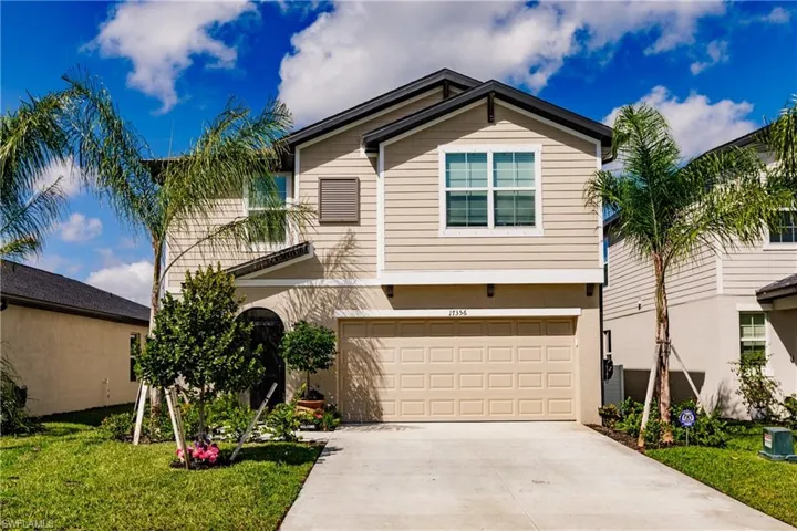 View of front of property featuring a garage and a front lawn