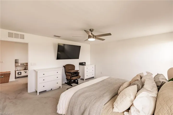 Bedroom with light colored carpet and ceiling fan