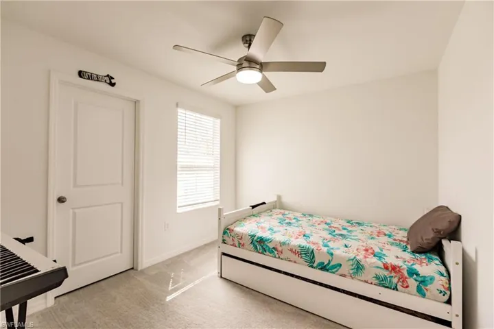 Bedroom with light carpet and ceiling fan