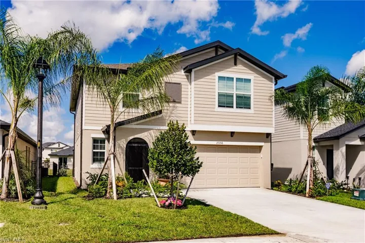 View of front of house with a garage and a front yard