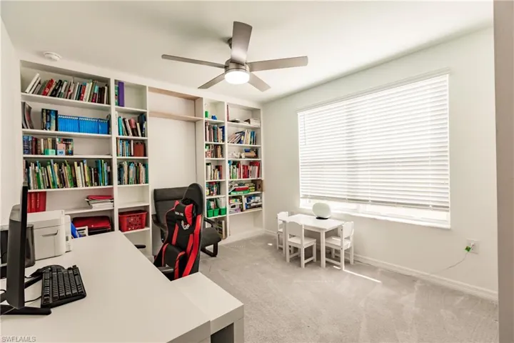 Office space with ceiling fan and light colored carpet