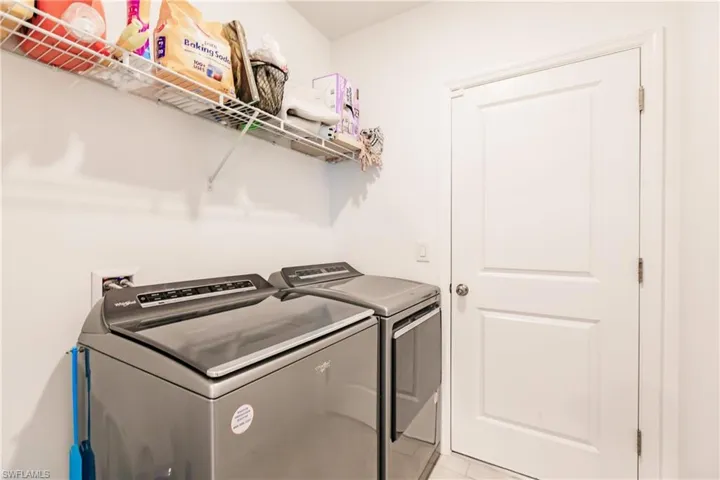 Washroom featuring washer and dryer and light tile patterned floors