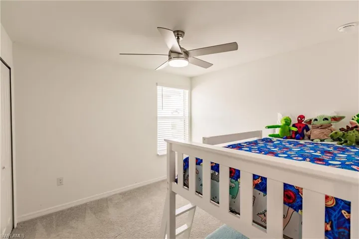 Carpeted bedroom featuring ceiling fan