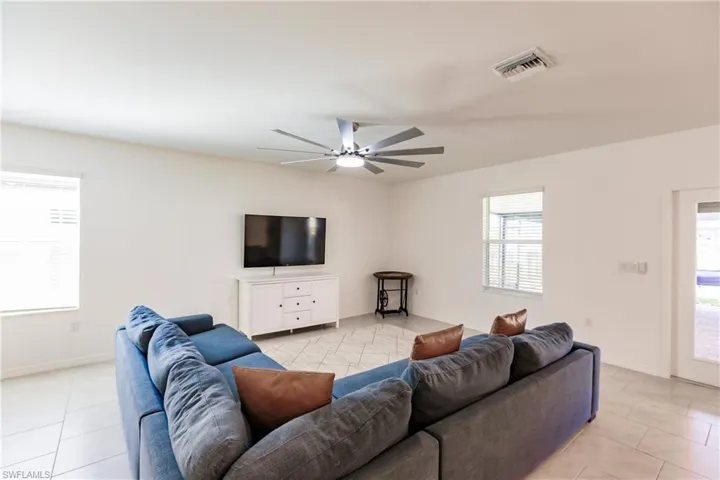 Living room with light tile patterned flooring and ceiling fan