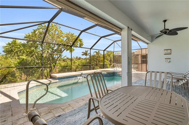 View of swimming pool featuring a patio area, a lanai, a pool with connected hot tub, and ceiling fan