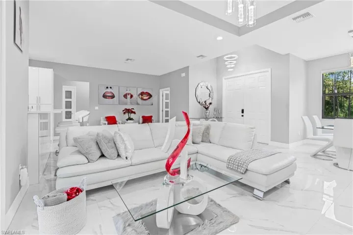 Living area featuring light marble finish floors, recessed lighting, and a chandelier