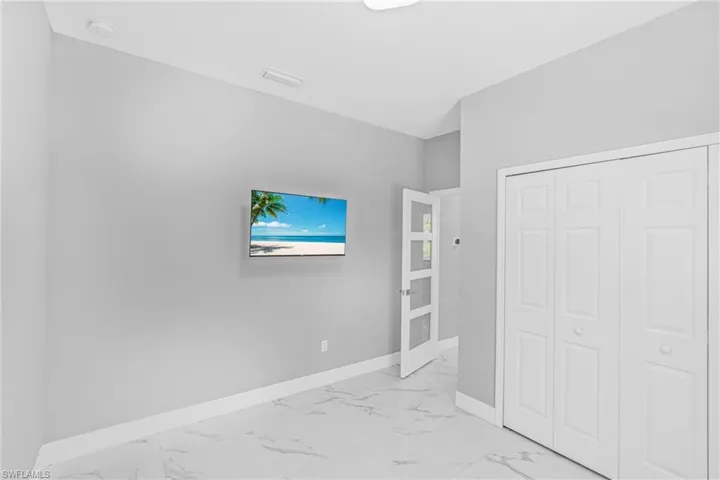 Unfurnished bedroom with light marble finish floors and a closet
