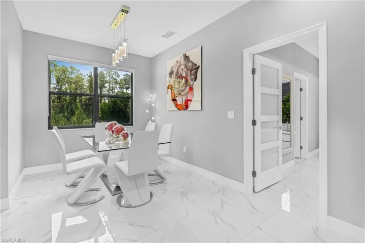 Dining space with light marble finish flooring and a chandelier