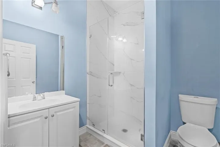 Bathroom with a marble finish shower and vanity