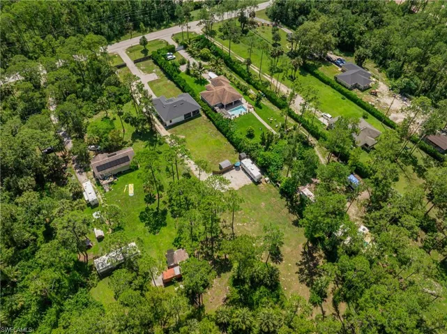 Aerial view of property's location featuring a tree filled landscape