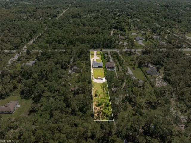 Aerial view of property and surrounding area featuring a forest and property boundaries highlighted