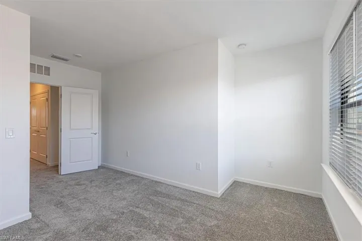 Empty room with carpet flooring and baseboards