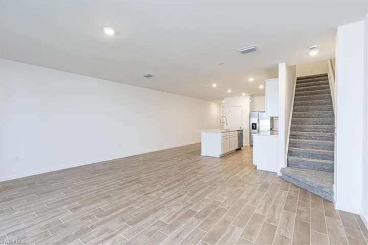 Unfurnished living room featuring stairway, recessed lighting, and wood tiled floors