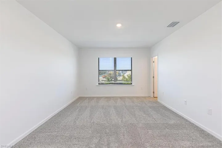 Carpeted spare room with baseboards