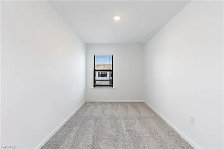 Empty room featuring light carpet and baseboards
