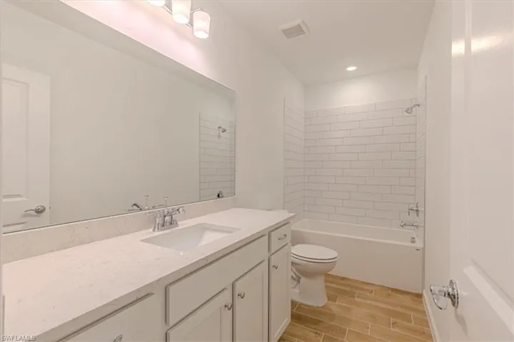Full bathroom with vanity, wood tiled floors, shower / bathtub combination, and recessed lighting