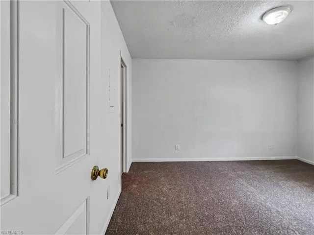 Unfurnished bedroom with a textured ceiling and carpet