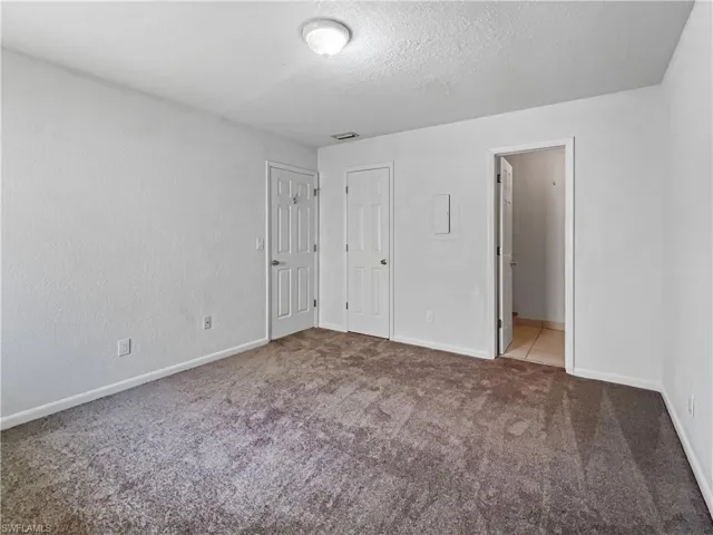 Unfurnished bedroom with carpet floors and a textured ceiling
