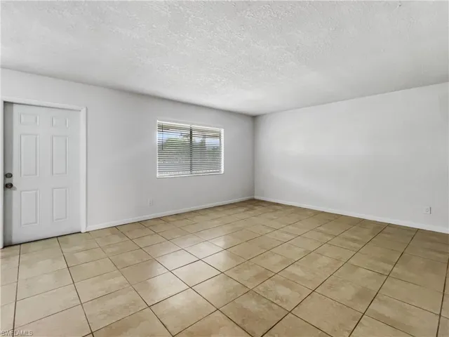 Spare room with a textured ceiling and light tile patterned floors