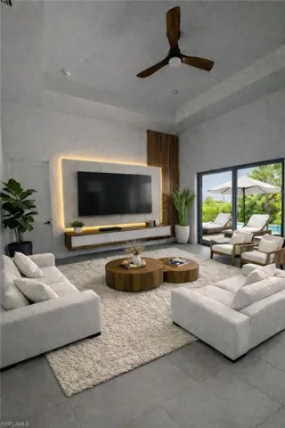 Living area featuring a ceiling fan and a towering ceiling