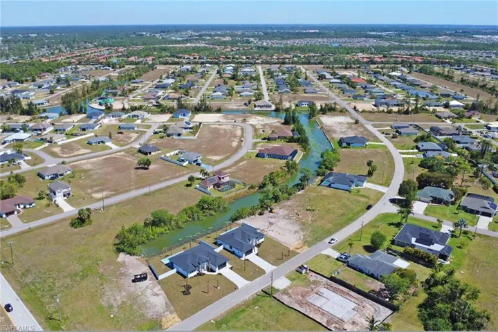 Aerial view of property's location with nearby suburban area and a nearby body of water