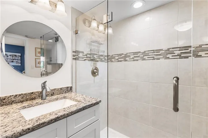 Bathroom with a shower with shower door and vanity