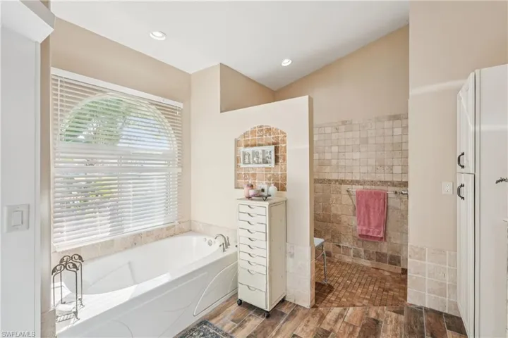 Bathroom featuring a garden tub and wood tiled floors