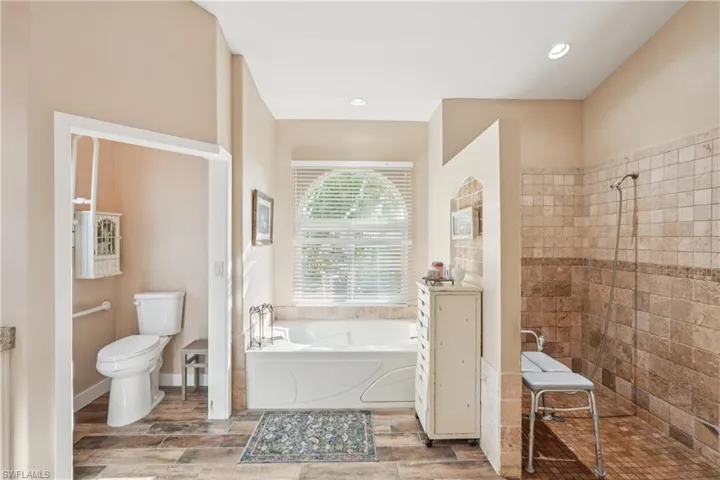 Full bathroom with a garden tub, a walk in shower, wood finish floors, and recessed lighting