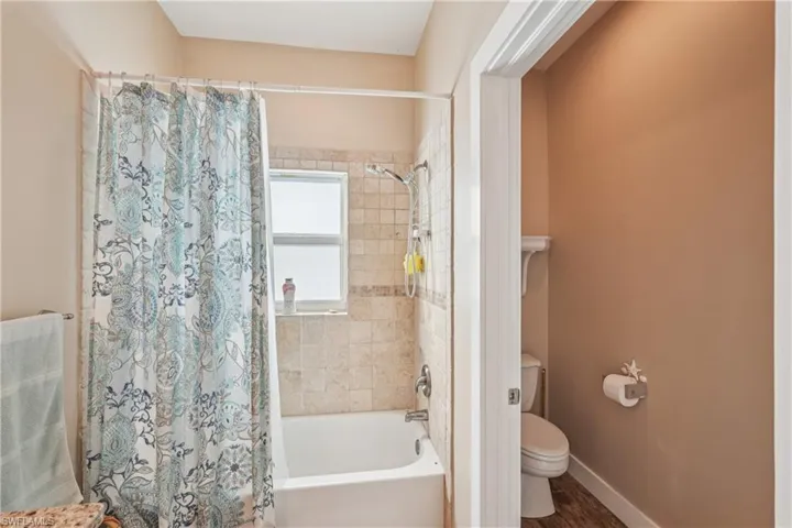 Full bathroom with shower / bath combo with shower curtain and wood finished floors