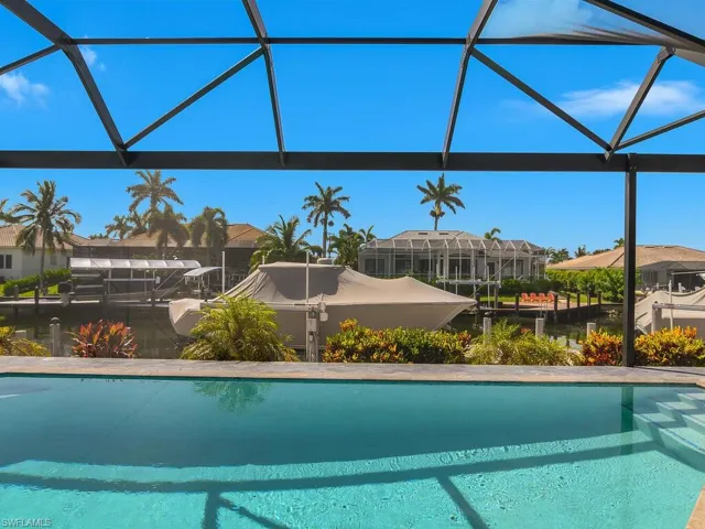 Outdoor pool with a residential view and glass enclosure