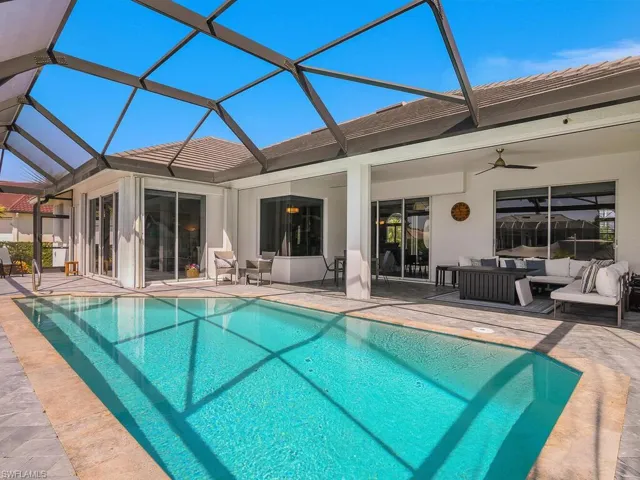 Outdoor pool featuring an outdoor living space, a patio, a ceiling fan, and glass enclosure