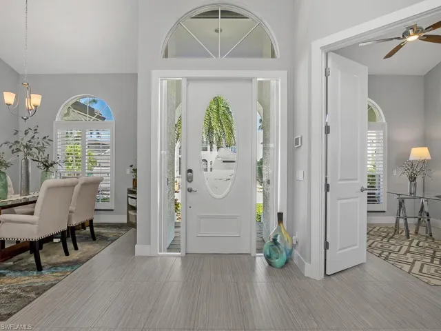 Foyer with a chandelier, a high ceiling, and a ceiling fan