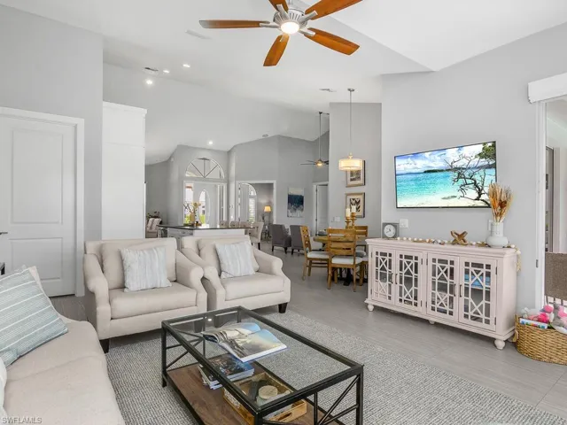 Living area with a ceiling fan, lofted ceiling, and recessed lighting