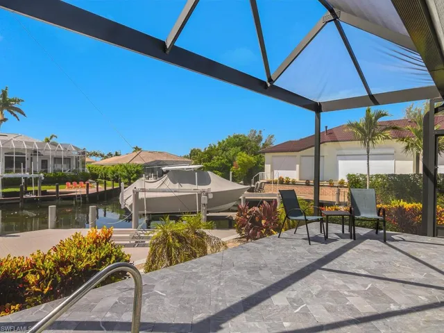 View of patio / terrace featuring a boat dock, boat lift, a lanai, and a water view