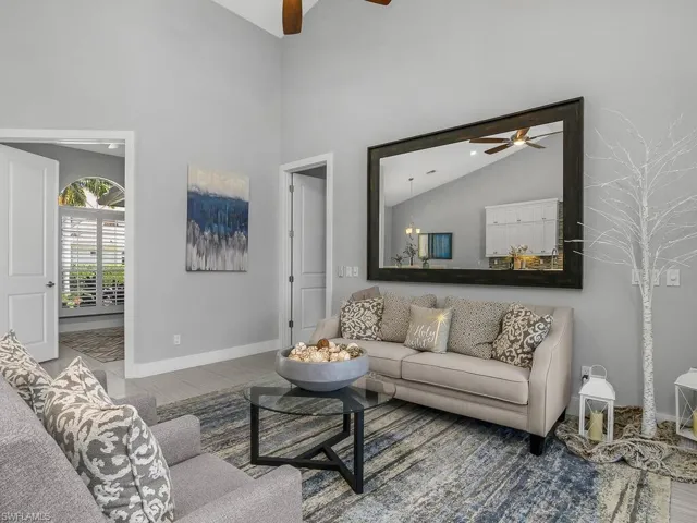 Living room featuring ceiling fan and high vaulted ceiling