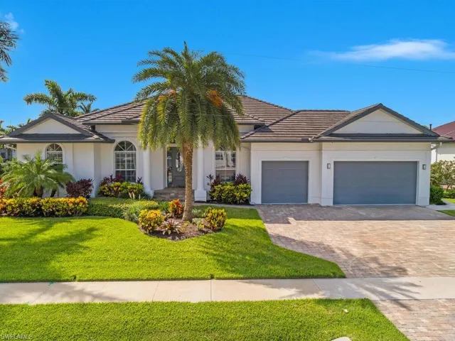 View of front of home with an attached garage, a front lawn, driveway, and stucco siding