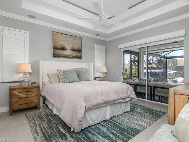 Bedroom with access to exterior, crown molding, a raised ceiling, and ceiling fan