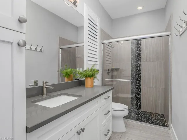 Full bath with vanity, a shower stall, and recessed lighting