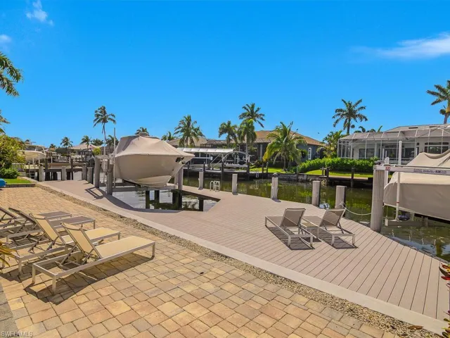 Dock area featuring boat lift, a water view, and a residential view