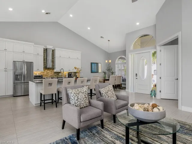Living area with high vaulted ceiling, recessed lighting, and a chandelier