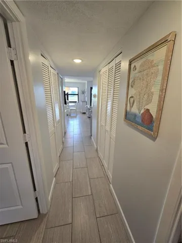 Hallway Showcases the Beautiful Porcelain Tile Flooring while Providing a Gateway from the Bedrooms to the Open Living Area!