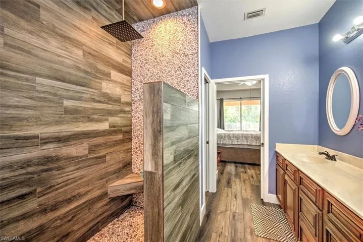 Bathroom with vanity, a shower, and hardwood / wood-style flooring