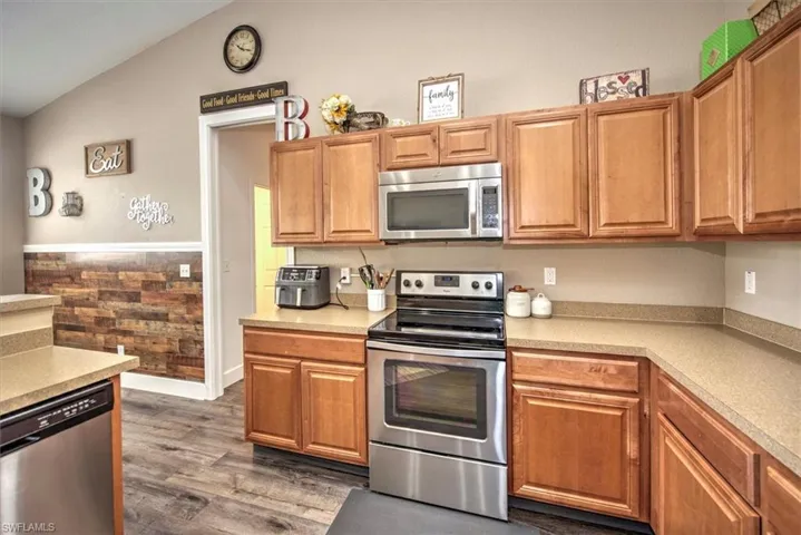 Kitchen featuring lofted ceiling, dark hardwood / wood-style floors, and stainless steel appliances