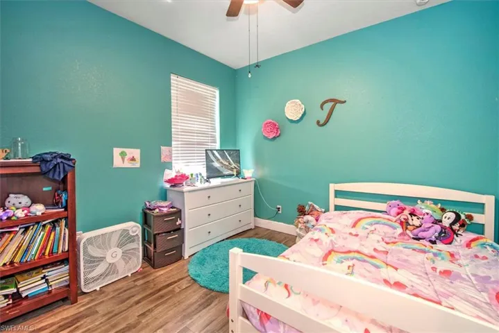 Bedroom with hardwood / wood-style floors and ceiling fan